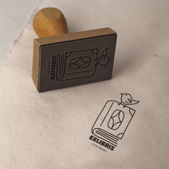 Sello ex libris pájaro sobre libro
